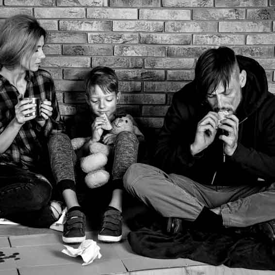 Una familia comiendo en la calle en situación de pobreza