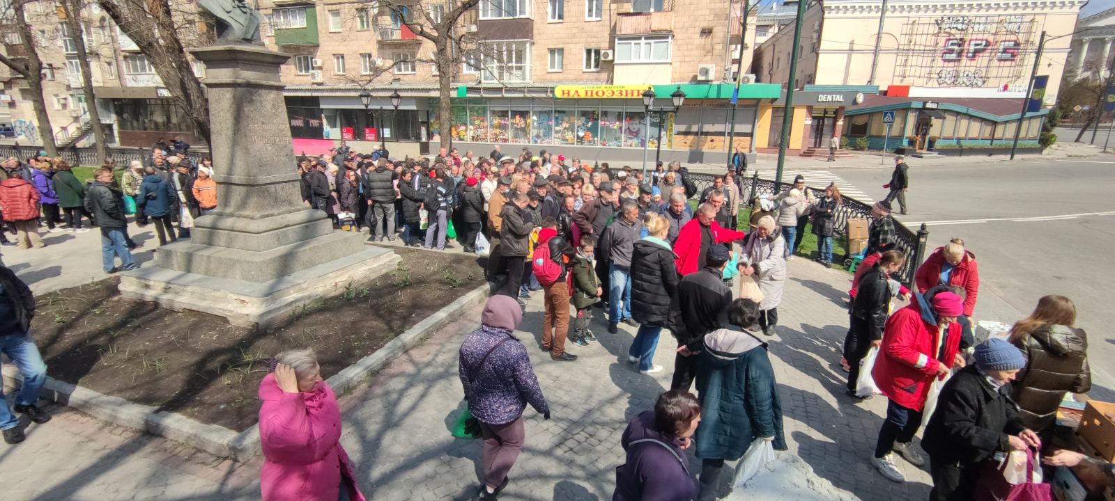 Multitud de personas en una plaza urbana.