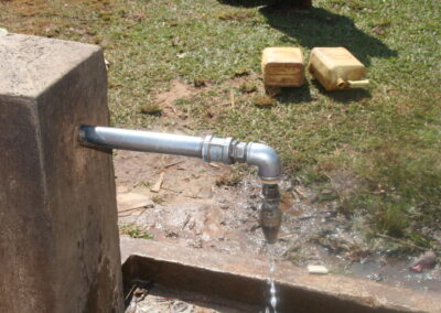 Grifo de agua con bidones vacíos en el suelo.