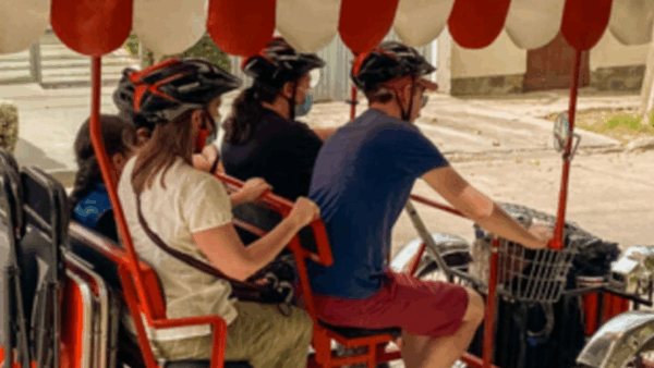 Personas en bicicleta cuadraciclo, casco rojo-negro.