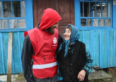 Hombre y mujer sonríen frente a casa azul.
